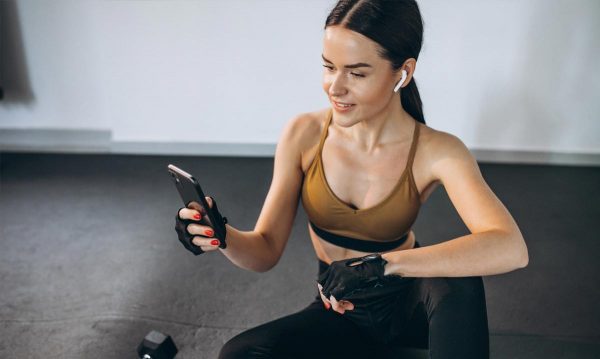young woman in work out clothing looking at her phone